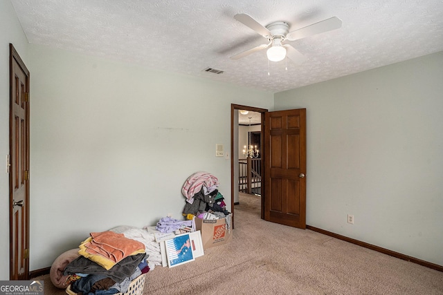 recreation room with light carpet, a ceiling fan, a textured ceiling, and baseboards