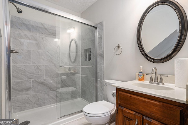 bathroom with a shower stall, toilet, and vanity