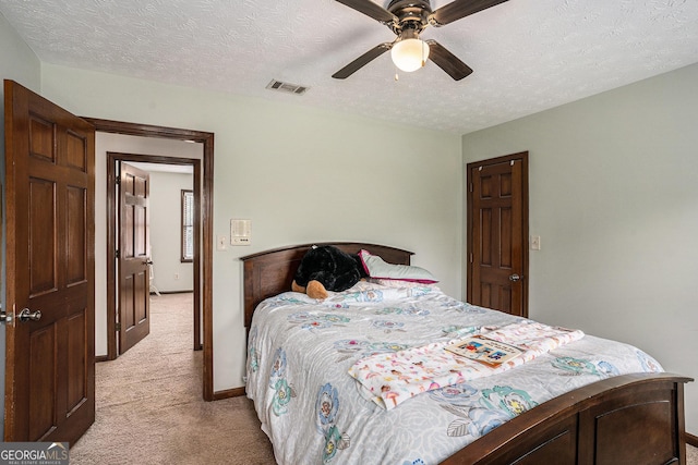 bedroom with light colored carpet, a textured ceiling, baseboards, and ceiling fan