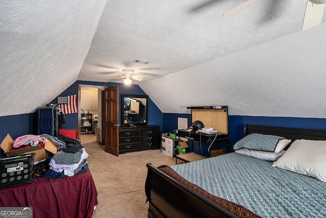 bedroom featuring carpet, lofted ceiling, a textured ceiling, and ceiling fan