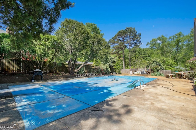 view of pool with a fenced backyard and a patio