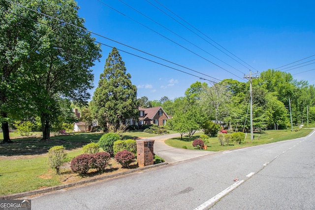 view of asphalt street with view of scattered trees