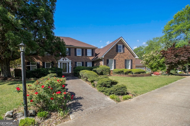 view of front facade with a front yard and brick siding