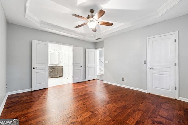 3911 Delfaire Trce, Cumming, GA 30040 - unfurnished bedroom featuring a raised ceiling, ornamental molding, dark wood finished floors, baseboards, and connected bathroom