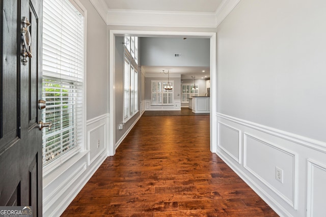 3911 Delfaire Trce, Cumming, GA 30040 - hallway featuring a decorative wall, ornamental molding, dark wood-style floors, wainscoting, and a chandelier