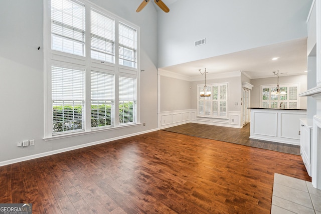 3911 Delfaire Trce, Cumming, GA 30040 - unfurnished living room featuring a chandelier, a high ceiling, dark wood-style floors, healthy amount of natural light, and a ceiling fan