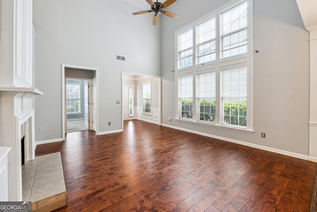 3911 Delfaire Trce, Cumming, GA 30040 - unfurnished living room with wood finished floors, a ceiling fan, a high ceiling, a fireplace with flush hearth, and baseboards