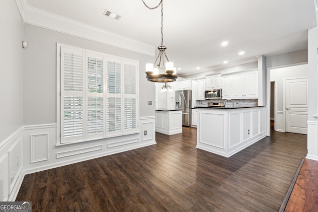 3911 Delfaire Trce, Cumming, GA 30040 - kitchen featuring stainless steel appliances, dark countertops, a chandelier, a sink, and ornamental molding
