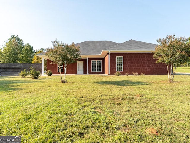 181 Bagley Rd, Eatonton, GA 31024 - view of front facade with brick siding, a front lawn, and fence