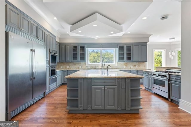 6509 Lily Trl, Fairburn, GA 30213 - kitchen featuring high quality appliances, open shelves, gray cabinetry, light stone counters, and ornamental molding