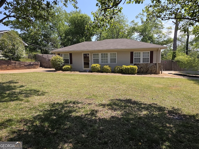 view of front of house with fence, a front lawn, and stone siding