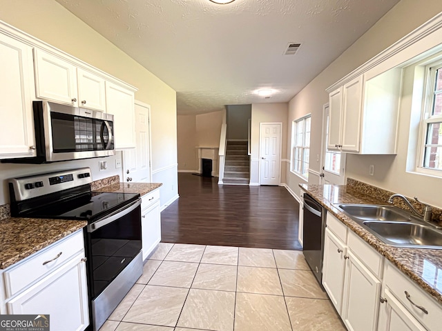 417 Bell Flower Trl, Locust Grove, GA 30248 - kitchen with a sink, a healthy amount of sunlight, stainless steel appliances, white cabinetry, and visible vents