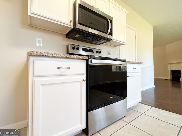 417 Bell Flower Trl, Locust Grove, GA 30248 - kitchen featuring baseboards, appliances with stainless steel finishes, white cabinetry, and light tile patterned floors
