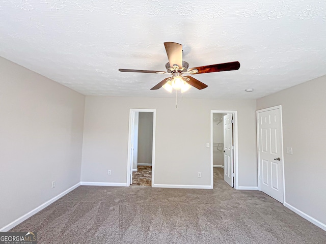 417 Bell Flower Trl, Locust Grove, GA 30248 - unfurnished bedroom featuring carpet floors, a spacious closet, a ceiling fan, and baseboards