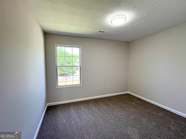 417 Bell Flower Trl, Locust Grove, GA 30248 - empty room with dark colored carpet, baseboards, and a textured ceiling