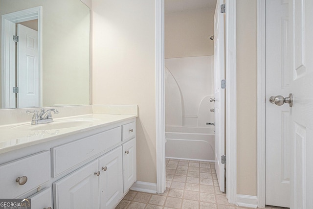 bathroom featuring vanity, tile patterned floors, baseboards, and  shower combination