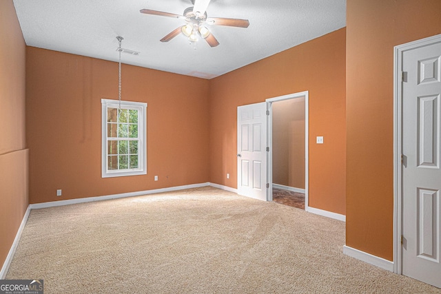 carpeted empty room featuring ceiling fan, baseboards, and visible vents