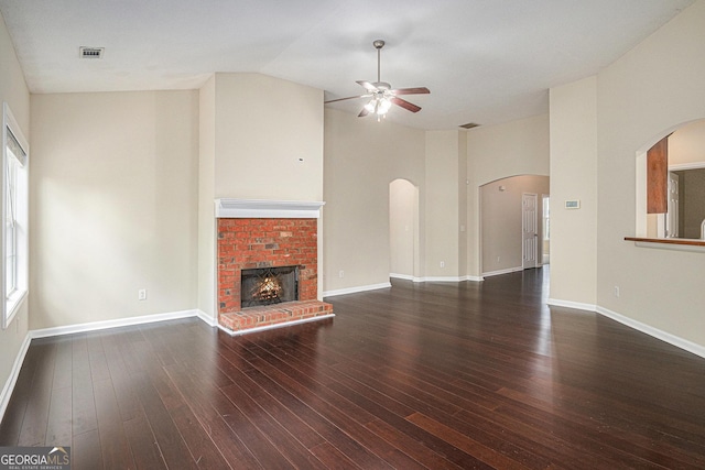 unfurnished living room featuring ceiling fan, arched walkways, wood finished floors, and visible vents