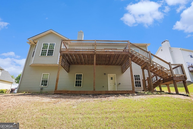 rear view of house with stairway, a wooden deck, a yard, and a carport