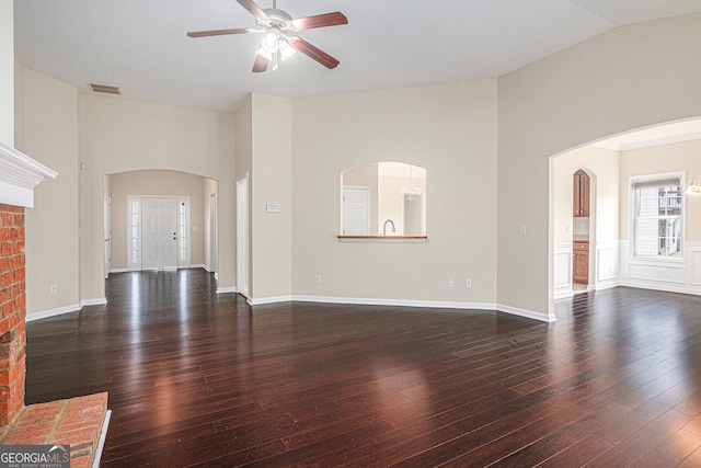 unfurnished living room with arched walkways, ceiling fan, lofted ceiling, and visible vents