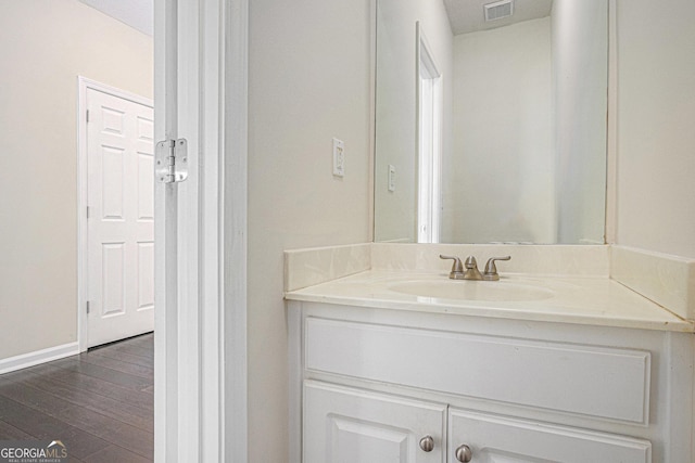 bathroom featuring baseboards, wood finished floors, visible vents, and vanity