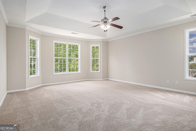 carpeted empty room with a ceiling fan, visible vents, ornamental molding, and a healthy amount of sunlight