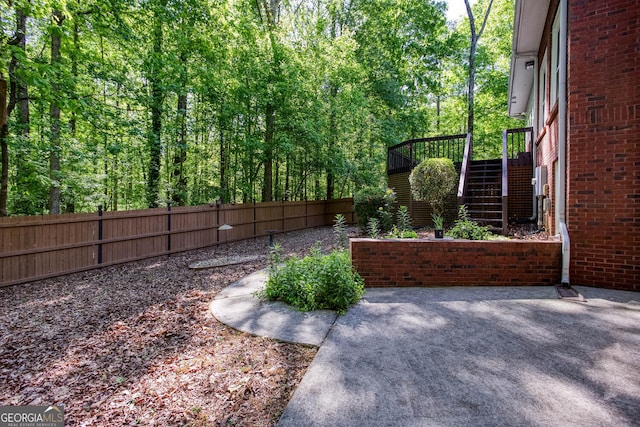 view of yard featuring fence, a patio, and stairs