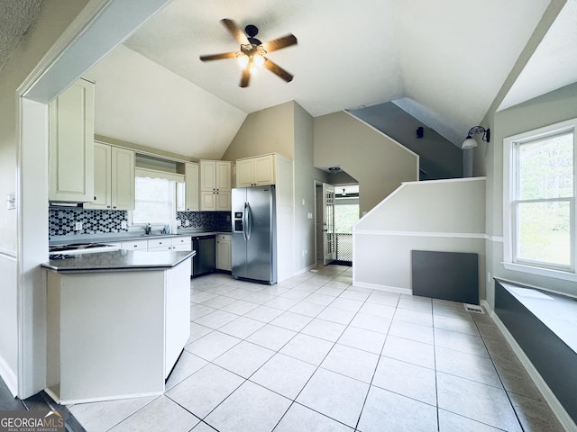 kitchen featuring decorative backsplash, ceiling fan, vaulted ceiling, dishwasher, and stainless steel fridge