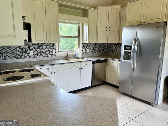 kitchen featuring light tile patterned floors, appliances with stainless steel finishes, decorative backsplash, and a sink