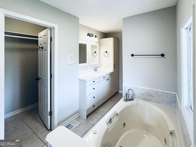 full bathroom with a sink, tile patterned flooring, double vanity, baseboards, and a tub with jets