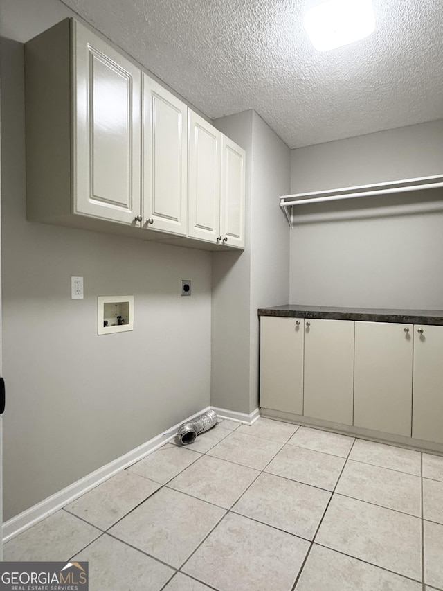 clothes washing area featuring baseboards, a textured ceiling, hookup for an electric dryer, cabinet space, and washer hookup