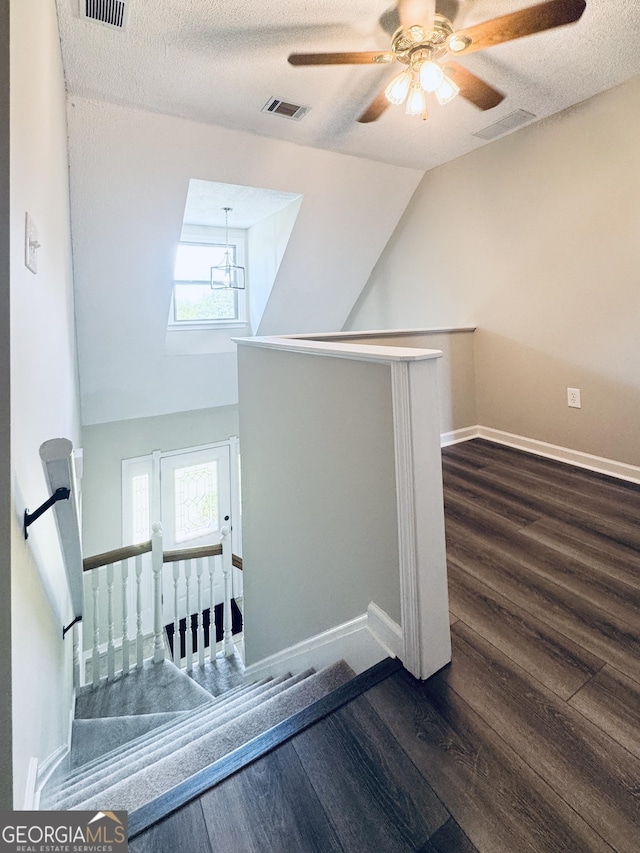 staircase featuring baseboards, wood finished floors, and a wealth of natural light