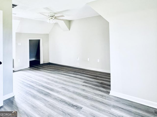 bonus room with baseboards, a ceiling fan, and wood finished floors