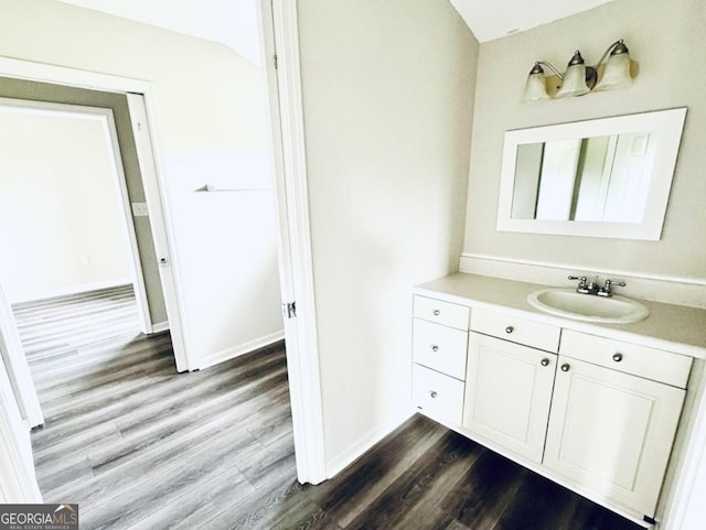 bathroom with vanity, baseboards, and wood finished floors