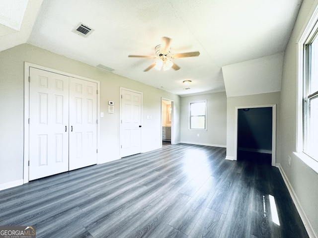 unfurnished bedroom featuring visible vents, a closet, baseboards, ceiling fan, and dark wood finished floors