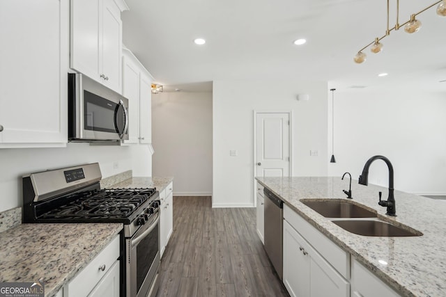 2946 Stockholm Way, Suwanee, GA 30024 - kitchen featuring white cabinets, dark wood-style floors, a sink, baseboards, and appliances with stainless steel finishes