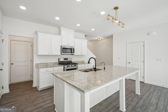 2946 Stockholm Way, Suwanee, GA 30024 - kitchen with white cabinets, dark wood finished floors, stainless steel appliances, a sink, and a kitchen island with sink
