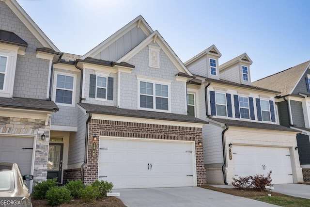 2946 Stockholm Way, Suwanee, GA 30024 - view of property featuring board and batten siding, an attached garage, brick siding, and concrete driveway
