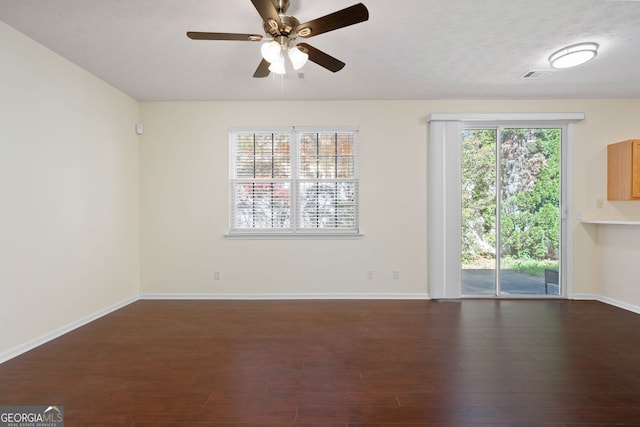 548 W Oaks Dr, Woodstock, GA 30188 - spare room featuring visible vents, a ceiling fan, baseboards, and dark wood-type flooring
