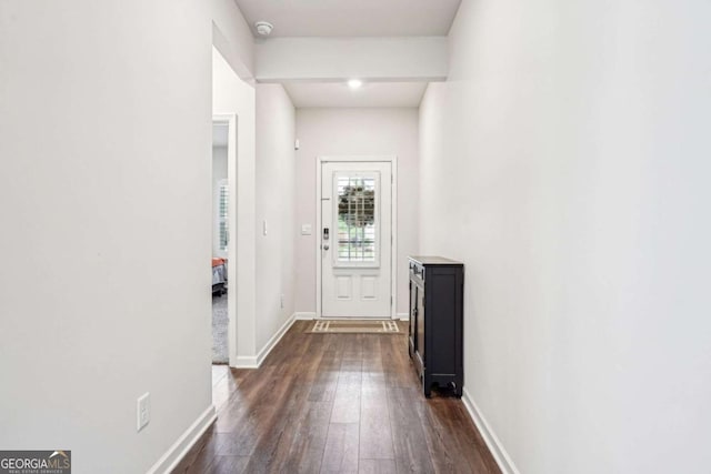 doorway to outside with baseboards and dark wood-type flooring