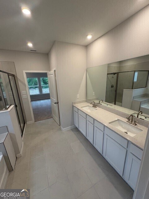 211 Park View Ln, Kingsland, GA 31548 - full bathroom featuring a shower stall, double vanity, recessed lighting, and baseboards