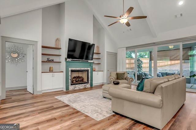 303 Wilsons Creek Bnd, Bonaire, GA 31005 - living room with visible vents, light wood-style floors, a tiled fireplace, a ceiling fan, and high vaulted ceiling