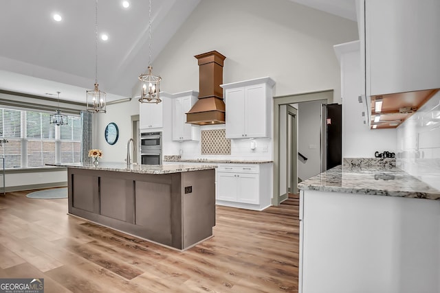 303 Wilsons Creek Bnd, Bonaire, GA 31005 - kitchen featuring a chandelier, premium range hood, high vaulted ceiling, and white cabinets
