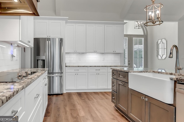 303 Wilsons Creek Bnd, Bonaire, GA 31005 - kitchen with black electric stovetop, stainless steel fridge, white cabinets, backsplash, and a sink