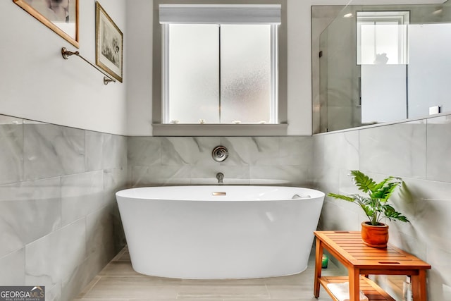 303 Wilsons Creek Bnd, Bonaire, GA 31005 - full bath with tile walls, a freestanding bath, and a wealth of natural light