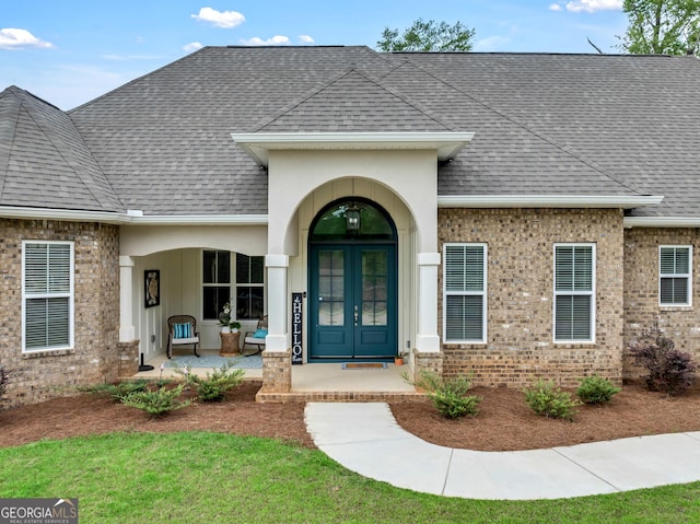 303 Wilsons Creek Bnd, Bonaire, GA 31005 - view of exterior entry with roof with shingles, french doors, and brick siding