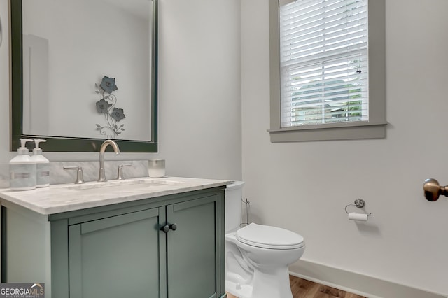303 Wilsons Creek Bnd, Bonaire, GA 31005 - bathroom featuring baseboards, wood finished floors, toilet, and vanity