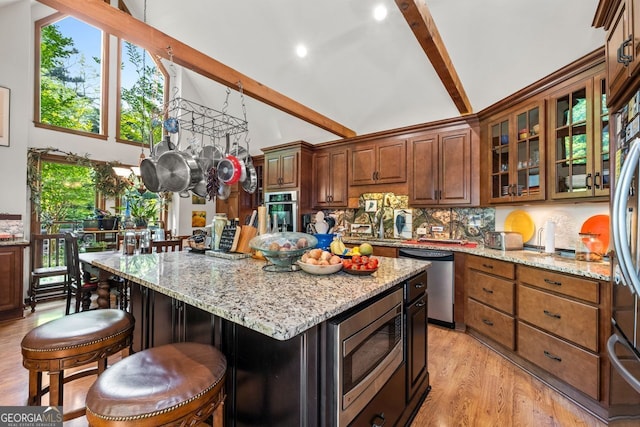 511 Oakdale Rd, Canton, GA 30114 - kitchen featuring beam ceiling, light stone counters, high vaulted ceiling, decorative backsplash, and appliances with stainless steel finishes