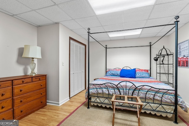 511 Oakdale Rd, Canton, GA 30114 - bedroom with light wood finished floors, a closet, baseboards, and a paneled ceiling