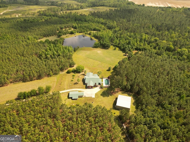 drone / aerial view with a forest view and a water view